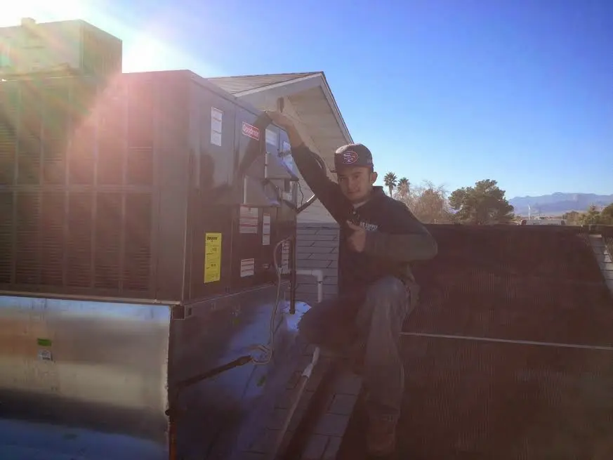HVAC technician performing AC Tune-Up on a rooftop unit in Sunbury